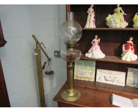 A brass corinthian column pedestal oil lamp with etched shade and glass chimney