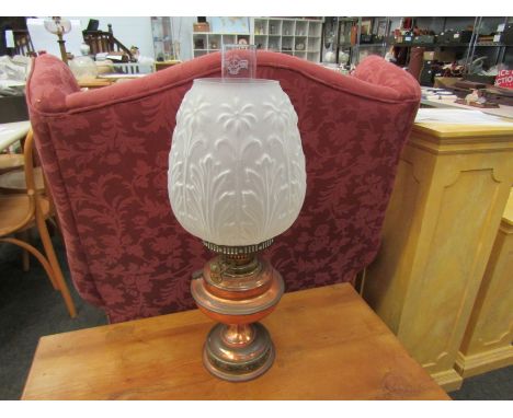 A copper based oil lamp with a frosted floral effect shade