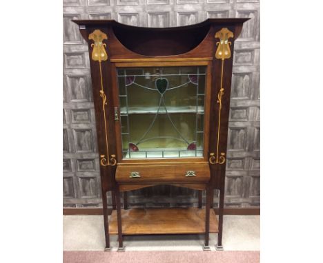 ATTRACTIVE ART NOUVEAU MAHOGANY DISPLAY CABINETwith cutaway cornice to wide top, the leaded and stained glass door enclosing 