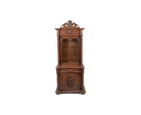 A late 19th Century North European carved oak breakfront cabinet on stand, the carved architectural pediment with boars head,