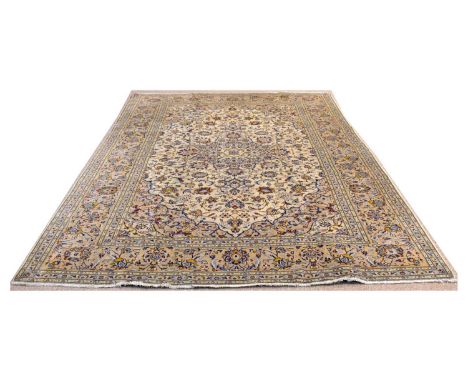 Kashan carpet, the central medallion and surrounding floral scrolls with blue colouring, on an ivory ground, 300 x 195cms. 