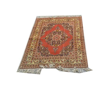 A Hadjijalili carpet, with central rosette of floral scrolls, on red ground, 172 x 123cms.