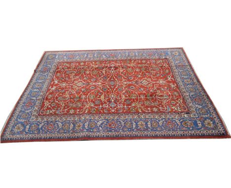 An Isfahan carpet, with floral scrolls on a red ground, 353 x 266cms.