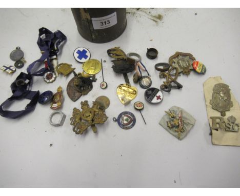 Tin containing a collection of various military cap badges and other enamel badges together with three trench art aluminium a