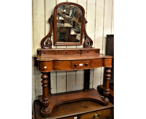 Victorian figured mahogany Duchess dressing table, the superstructure with a swing mirror on carved supports above three jewe