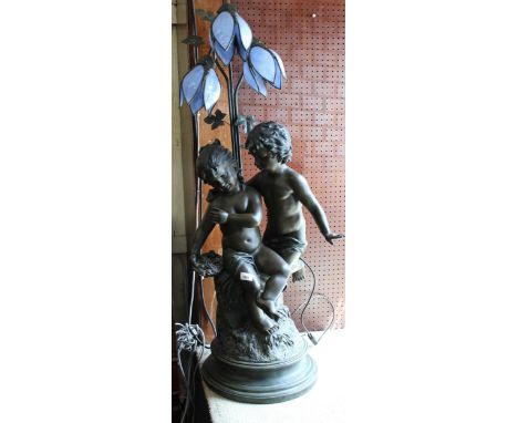 Large bronzed composition floor lamp in the form of two children beneath stylised floral design blue shades, 41ins high overa