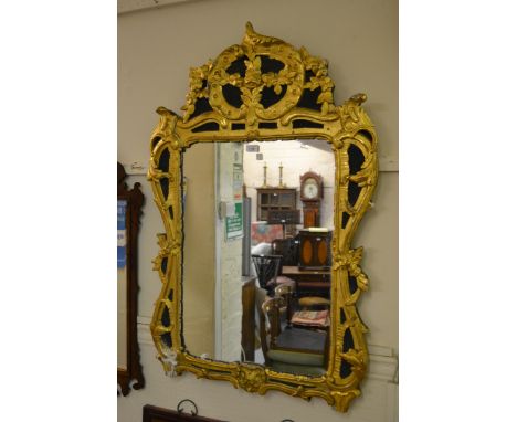 18th Century Irish carved and gilded wall mirror, the floral surmount above a rectangular plate with floral surround and ebon