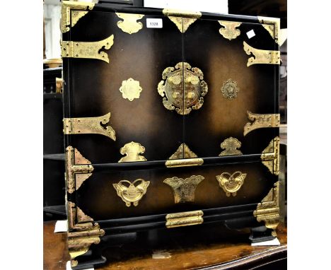 Small lacquer and brass mounted cabinet, the two doors enclosing three small drawers above a further drawer on bracket feet, 