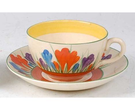 A Clarice Cliff Crocus pattern pottery teacup and saucer, each with Crocus Bizarre by Clarice Cliff Wilkinson Ltd England bla