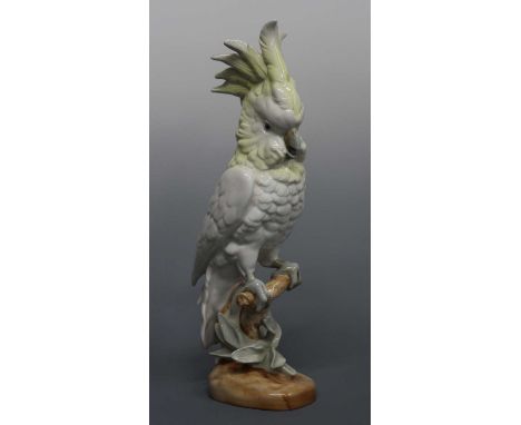 A large Royal Dux ceramic figure of a parrot, underglaze painted in muted tones, perched on a naturalistic stump, with typica