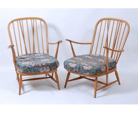 A pair of 1960s Ercol light elm stickback open armchairs, each with floral patterned cushions and webbed seats, w.70cmConditi