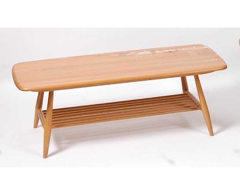 An Ercol light elm low coffee table, the rounded top raised on turned supports to laddered undertier, h.36.5cm, length 104cm,
