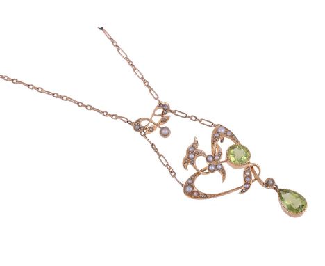 AN EDWARDIAN PERIDOT AND SEED PEARL PENDANT NECKLACE CIRCA 1910The scrolled foliate whiplash pendant set with half seed pearl