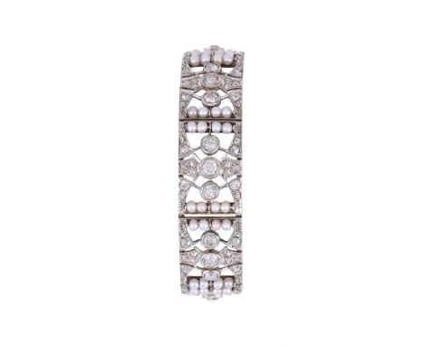 AN EARLY 20TH CENTURY DIAMOND AND PEARL BRACELET CIRCA 1920The pierced panels each set with a trio of old mine cut diamonds w