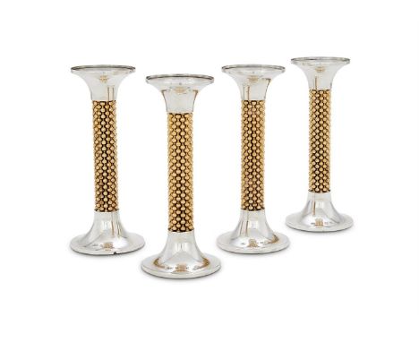 A SET OF FOUR SILVER AND SILVER GILT CANDLESTICKSROBERT WELCH, BIRMINGHAM 1971With circular sconces, beaded gilt stems and on