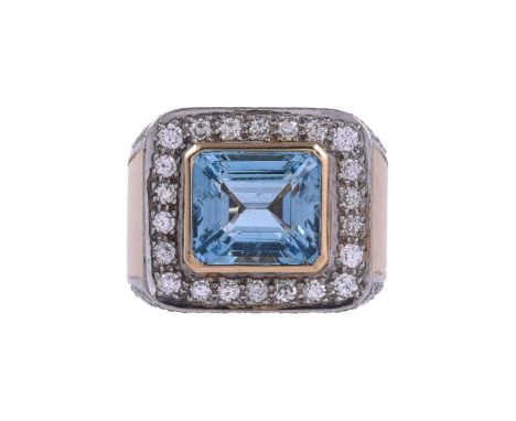 AN AQUAMARINE AND DIAMOND CLUSTER RINGThe step cut aquamarine with canted corners, within a surround of brilliant cut diamond