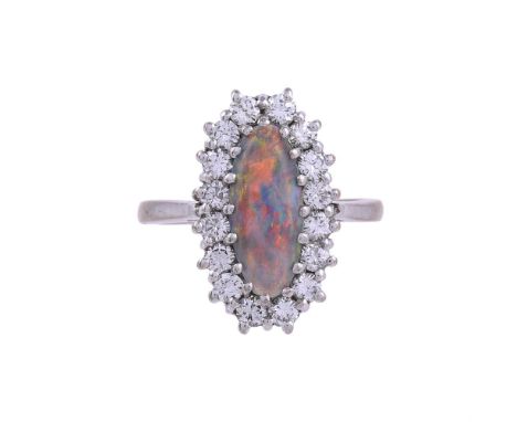 A BLACK OPAL AND DIAMOND CLUSTER RING LONDON 1975The oval cabochon black opal within a surround of brilliant cut diamonds, ap