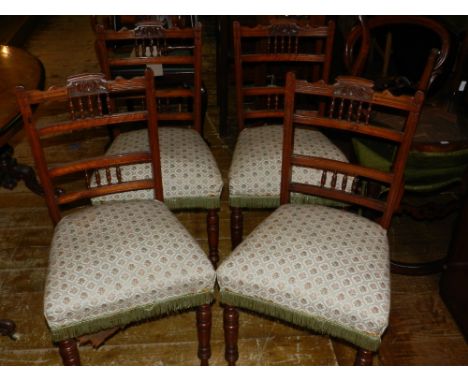 A set of four Edwardian walnut dining chairs, with bobbin rail backs overstuffed seats and turned tapering legs, (4).