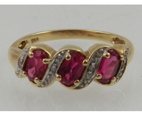 A 9 carat yellow gold and ruby ring, set three oval cut rubies, the mount set with diamond accents.