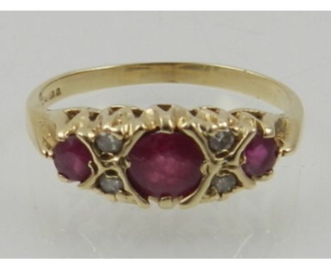 A 9 carat yellow gold, diamond, and ruby ring, set three graduated rubies interspersed with small diamonds. 