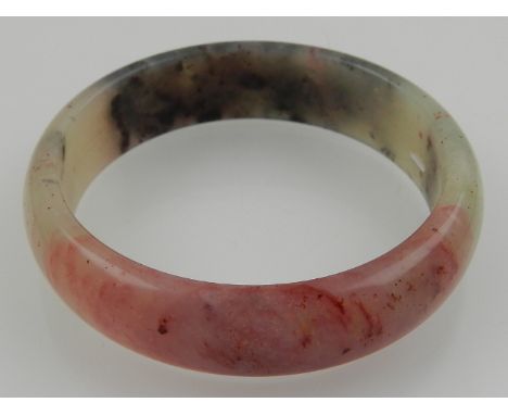 A Chinese red and black hardstone bangle. 
