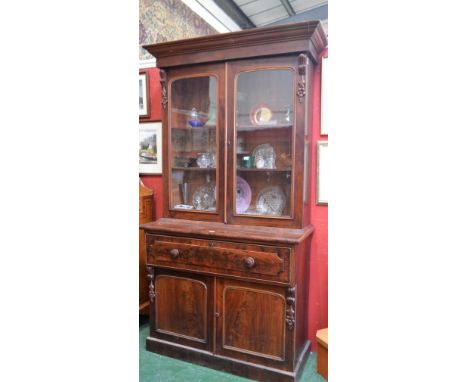 A Victorian mahogany secretaire bookcase, outswept cornice above a pair of glazed doors enclosing two adjustable shelves, the