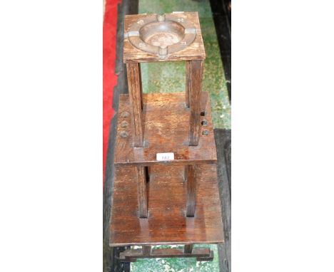 An Arts &amp; Crafts oak smoking stand, composed of three graduated square tiers, the upper containing an ash tray moulded wi