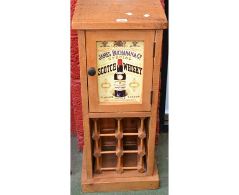 A pine advertising drinks cabinet, inset panel door advertising James Buchanan Scotch Whisky, above wine rack base