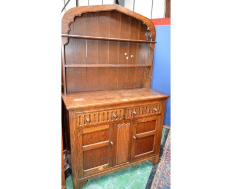 A 20th century oak Welsh type dresser, arched apron above two plate racks, the base with two short drawers above a pair of cu