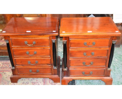 A pair of Biedermeier style mahogany bedside chests, each with an oversailing rectangular top above four drawers flanked by a