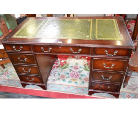 A mahogany twin pedestal writing desk, rectangular top with inset writing surface above three frieze drawers, further drawers