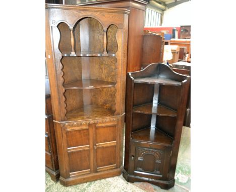 A 20th century oak floor standing corner display cabinet, moulded cornice above two shaped shelves and a pair of panel doors 