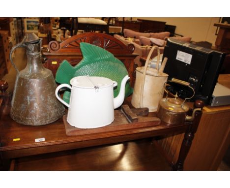 A large enamel teapot; a painted watering can; a brass and copper swing handled kettle; a wooden boot pull; a metal ware mode