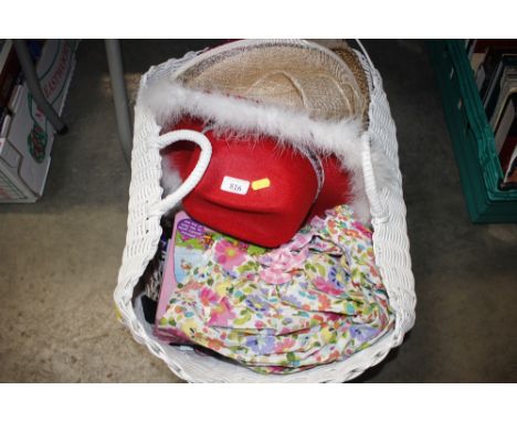 A wicker basket and contents to include hats, various textiles etc.
