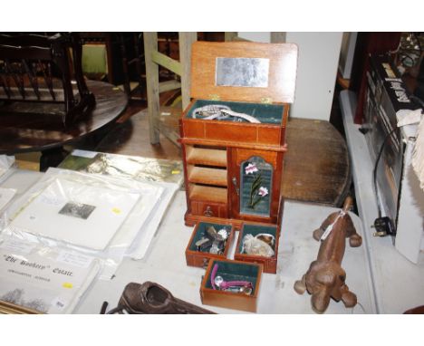 A mahogany effect trinket cabinet and some contents 