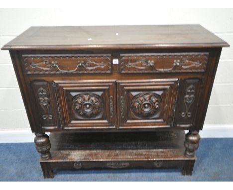 AN EARLY 20TH CENTURY OAK BUFFET, fitted with two drawers, over double cupboard doors, raised on turned front legs, united by