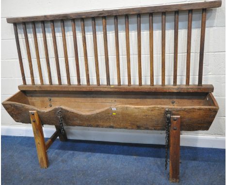 A CATTLE TROUGH, with various alterations and timbers, later legs, with a cattle guard, length 202cm x depth 42cm x height 15