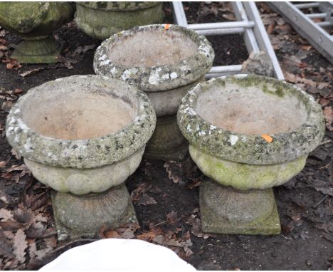A SET OF THREE WEATHERED COMPOSITE GARDEN PLANTERS with fluted detail to blustered bowls, Condition Report: repaired break to