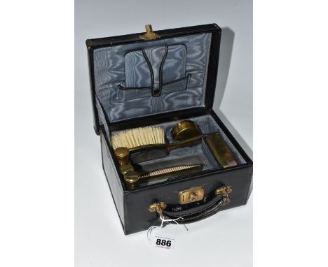 A PORTABLE VINTAGE VANITY KIT comprising a mirror (stitching from its holder loose), a hairbrush with a brass handle, a nail 
