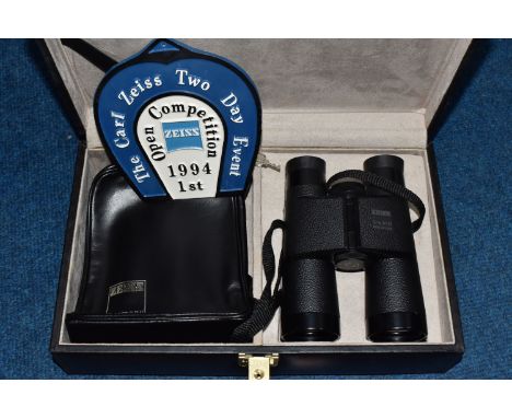 A BOXED PAIR OF ZEISS BINOCULARS comprising a boxed pair of Zeiss 10 x 40B binoculars, a leather pouch, and a metal 'Carl Zei