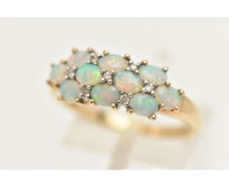 A 9CT GOLD OPAL CLUSTER RING, ten oval cabochon opals prong set in yellow gold, with seven single cut diamond accents, leadin