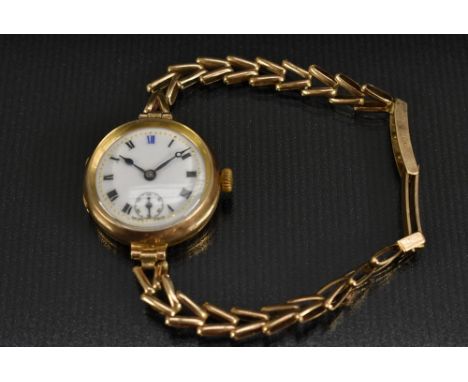 Visible - a vintage 1920s 9ct gold bracelet watch, enamel dial, black Roman numerals with blue XII, outer minute track, subsi