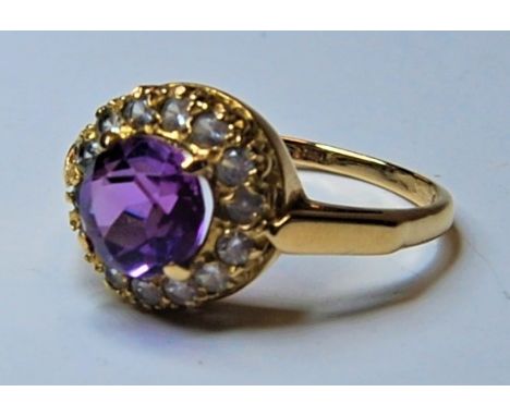 A ladies 9ct gold and amethyst dress ring, the central amethyst surrounded by 14 small diamonds in claw setting, ring size P,