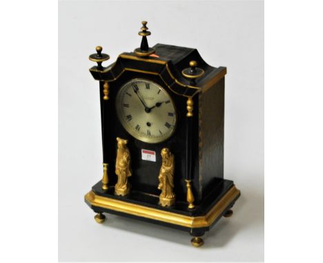 An early 20th century green and gilt painted mantel clock of pagoda shape with turned finials surmounted by two gilt Japanese