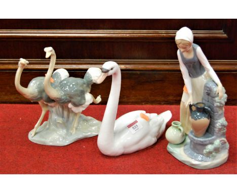 A Lladro porcelain figure of a swan together with a Nao figure group of two ostriches, and a Nao porcelain figure of a woman,