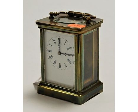 A lacquered brass cased carriage clock having enamel dial with Roman numerals, visible platform lever escapement and barrel g