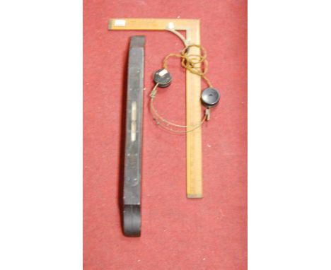 An early 20th century wooden spirit level, together with a wooden set square and pair of headphones