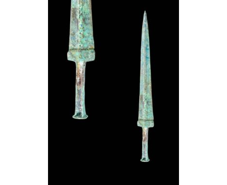 Ca. 1100 - 900 BC.
A moulded bronze dagger with a short, tapering blade, a prominent midrib and a guard. The hilt is characte