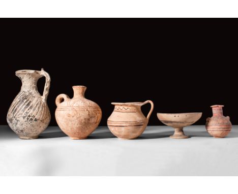 Ca. 500 - 300 BC.
A set of six vessels comprising three jugs, a cup and a petite bottle. The first has a ribbed and twisted d