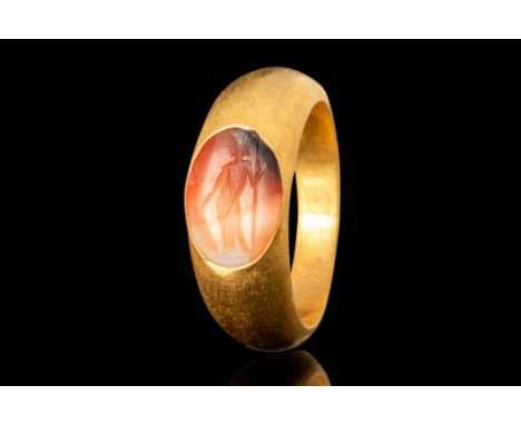 Ca. AD 100 - 300.
A gold ring with a D-section round hoop with enlarged shoulders forms a bezel securing a carnelian intaglio